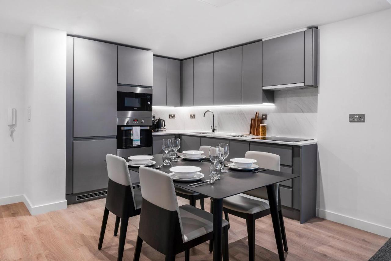 Citysuites 2 Aparthotel 曼彻斯特 外观 照片 The photo shows a modern kitchen and dining area. The kitchen features sleek, gray cabinetry and a countertop that complements the overall aesthetic. There are built-in appliances, including an oven and refrigerator, arranged neatly. Next to the kitc