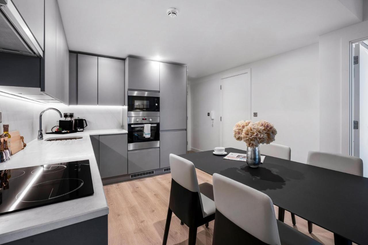 Citysuites 2 Aparthotel 曼彻斯特 外观 照片 The photo shows a modern kitchen and dining area. The kitchen features sleek gray cabinets, a countertop with an embedded cooktop, and built-in appliances, including an oven and microwave. There’s a small coffee maker on the counter. Adjacent to the 