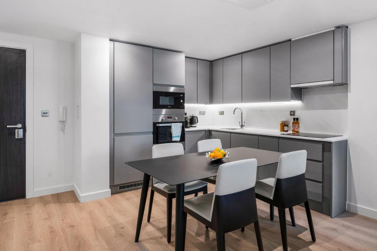 Citysuites 2 Aparthotel 曼彻斯特 外观 照片 The photo shows a modern kitchen with a sleek and minimalist design. The cabinetry features a gray finish, and there are built-in appliances, including an oven and possibly a microwave. The countertop is light-colored, providing contrast to the darke